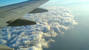 Uçuş sırasında uçağın kanatları altında beyaz bulutlar