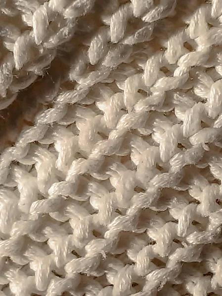 Knitted pattern from white wool. knitted fabric, handmade