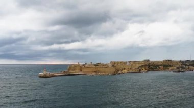 Malta kıyısı, deniz feneri ve Valleta limanına giden gemi.