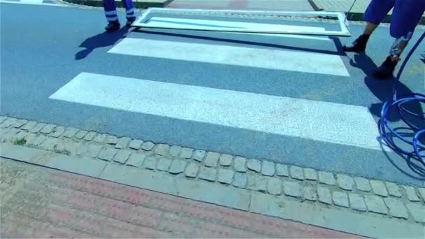 道路横断歩道の整備 道路作業員が横断歩道標識にペンキを塗る — ストック動画
