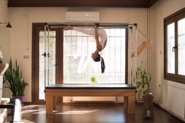 Genç kadın Pilates eğitmeni Pilates Reformer üzerinde egzersiz