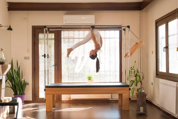 Genç kadın Pilates eğitmeni Pilates Reformer üzerinde egzersiz