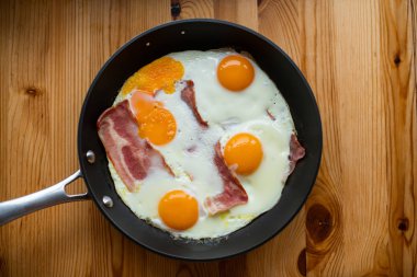 Güneşli tarafı yukarı yumurta pastırmalı bir tavada