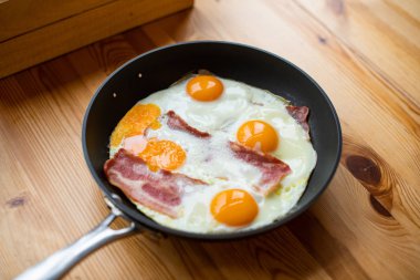 Güneşli tarafı yukarı yumurta pastırmalı bir tavada