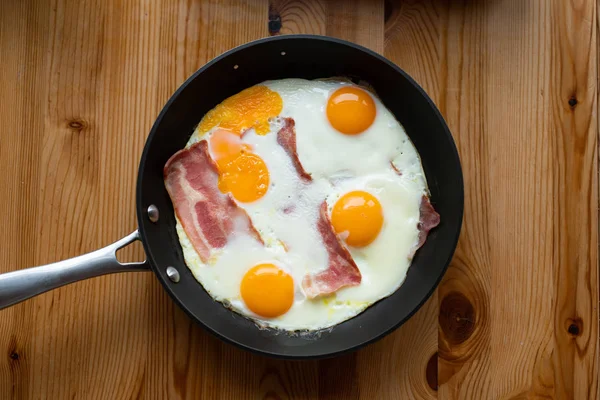Sunny Side Up Eggs with Bacon, in a pan