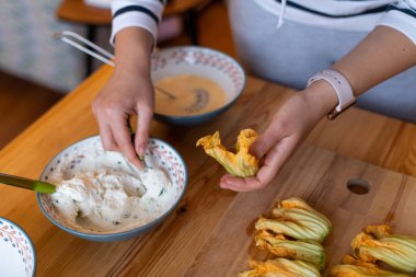 Ricotta peyniri, gösterilen kadın eli ile doldurulmuş kabak çiçekleri hazırlanıyor
