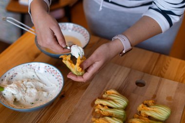 Ricotta peyniri, gösterilen kadın eli ile doldurulmuş kabak çiçekleri hazırlanıyor
