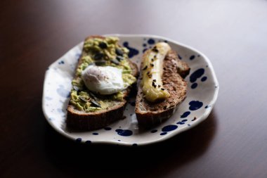 haşlanmış yumurta ve kızarmış muz ile badem tereyağlı ekmek ile avokado tost