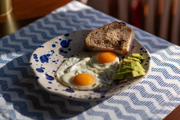 sunny side up eggs with sliced avocado