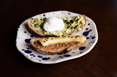haşlanmış yumurta ve kızarmış muz ile badem tereyağlı ekmek ile avokado tost