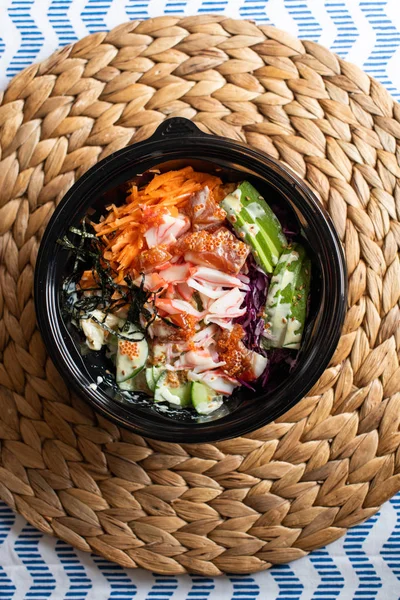 hawaii poke bowl with salmon, rice, surimi, avocado, tobiko, car