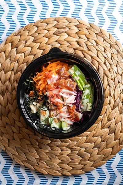 hawaii poke bowl with salmon, rice, surimi, avocado, tobiko, car