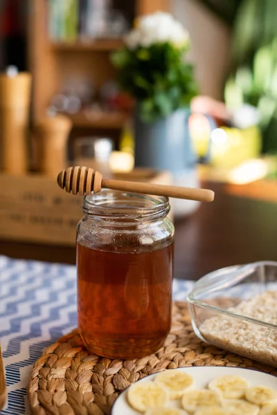 Honey jar with wooden honey dipper on top of it — Stock Photo, Image