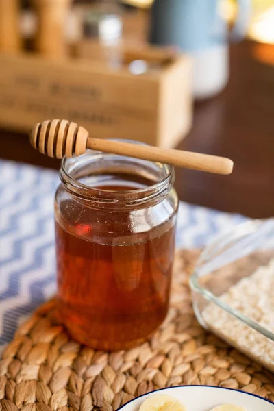 Βάζο μελιού με μέλι ξύλινη κουτάλα πάνω — Φωτογραφία Αρχείου