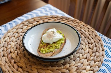 Haşlanmış yumurta ile avokado tost. bir tabakta