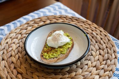 Haşlanmış yumurta ile avokado tost. bir tabakta