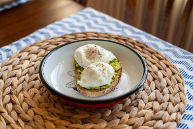 Haşlanmış yumurta ile avokado tost. bir tabakta