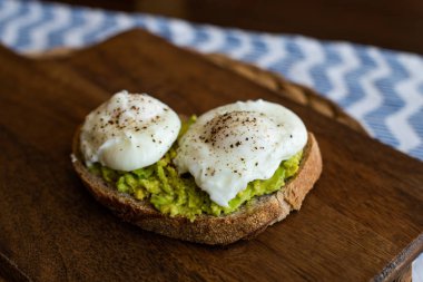 Haşlanmış yumurta ile avokado tost. Koyu ahşap yüzeyde hizmet