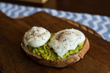 Haşlanmış yumurta ile avokado tost. Koyu ahşap yüzeyde hizmet