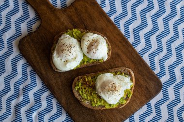 Haşlanmış yumurta ile avokado tost. Koyu ahşap yüzeyde hizmet
