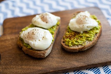 Haşlanmış yumurta ile avokado tost. Koyu ahşap yüzeyde hizmet