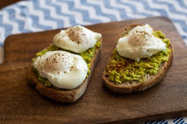 Haşlanmış yumurta ile avokado tost. Koyu ahşap yüzeyde hizmet