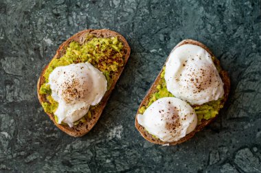 Haşlanmış yumurta ile avokado tost. Yeşil Mermer yüzey üzerinde hizmet