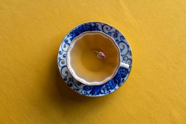 Antik bir porselende servis edilen kurutulmuş gül çiçekli beyaz çay.