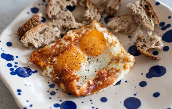 Fried eggs with sesame, served with sour dough toast — Stock Photo, Image