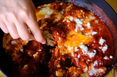 Shakshuka kızartma tavasında. Baharatlı domates soslu haşlanmış yumurta..