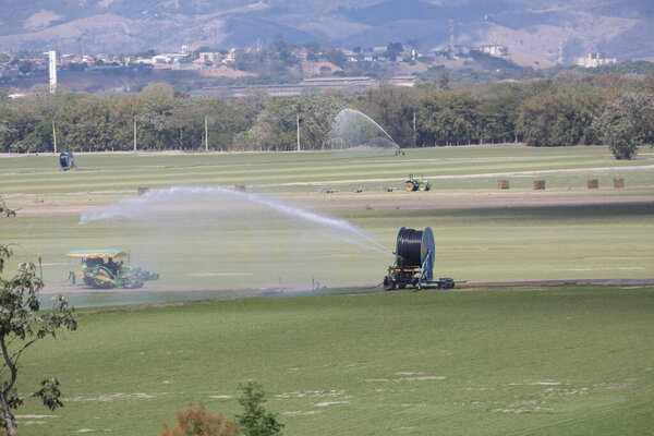 Tractors and irrigation systems work in sync, showcasing the power of modern farming, technology in the field, and the importance of sustainable food production for the future.