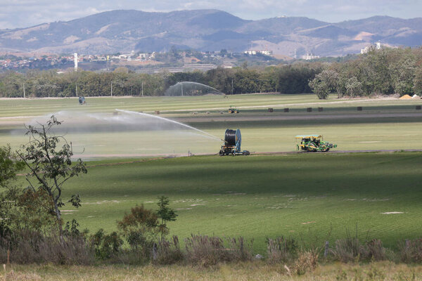 Tractors and irrigation systems work in sync, showcasing the power of modern farming, technology in the field, and the importance of sustainable food production for the future.