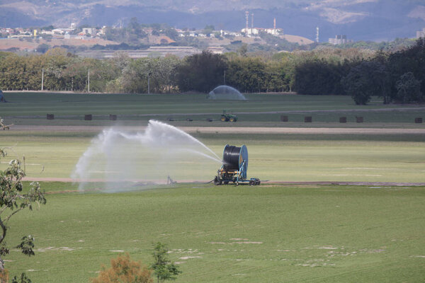 Tractors and irrigation systems work in sync, showcasing the power of modern farming, technology in the field, and the importance of sustainable food production for the future.