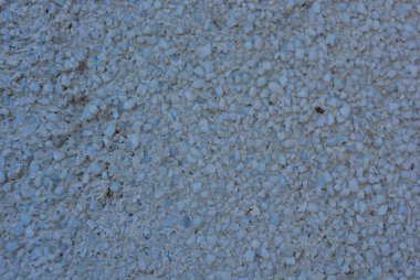 Bütün kare içinde küçük gri taş olan beton duvar