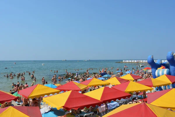 Karadeniz Kıyısında Turistler Tatilcilerin Olduğu Parlak Kırmızı Plaj Şemsiyeleri — Stok fotoğraf