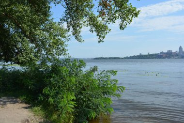 Şehir, nehir ve yeni evler ikinci kıyı ve üstlerindeki beyaz bulutlar sol yakasında yeşil ağaçlar, İtalyan yatay