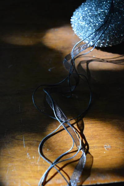金属海绵与透明黑丝带和黑色螺纹在棕色木桌与太阳射线 — 图库照片