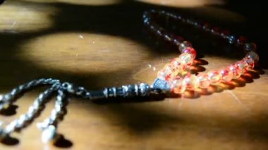 Sarı ve kırmızı boncuk üzerinde bir vernikli ahşap Müslüman dini boncuk eski tablo stili güneş ışınları tarafından yaktı