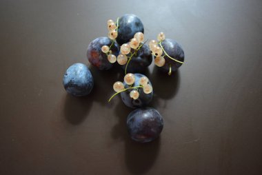 Taze erik sökük ve kahverengi mat arka plan üzerinde beyaz frenk üzümü, demet