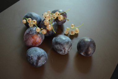 Taze erik sökük ve kahverengi mat arka plan üzerinde beyaz frenk üzümü, demet