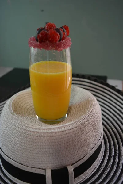 女性夏帽子は グラスにオレンジ ジュース リム桜赤糖 ラズベリー グーズベリー トップ フルーツ — ストック写真