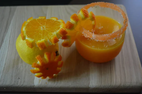 レモン 個とニンジンとオレンジ ジュースのグラス 杯砂糖軽い木製の背景の縁 オレンジ スライス — ストック写真