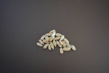 Kahverengi arka planda siyah kabuksuz kavrulmuş ayçekirdeği..