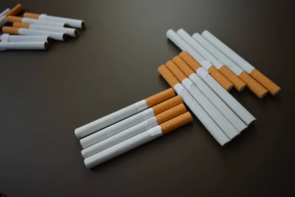 Kahverengi bir arka planda birçok sigara çürümüş..