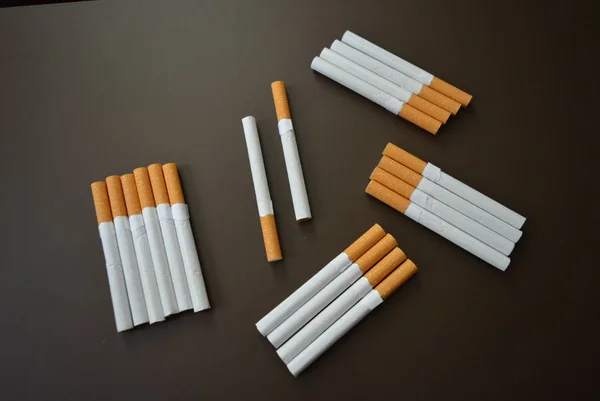 新的香烟在褐色的衬垫上分解了许多香烟 — 图库照片