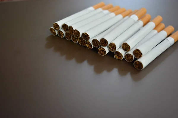 Kahverengi bir arka planda birçok sigara çürümüş..