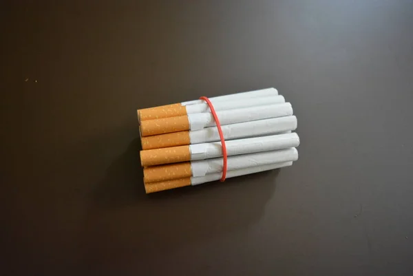 Cigarros Embalagem São Fixados Com Elástico Vermelho Sobre Fundo Fosco — Fotografia de Stock