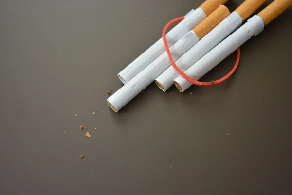 包装上的香烟用红色橡皮筋固定在褐色的衬垫上 — 图库照片