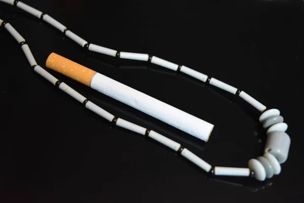 One Cigarette Gray Female Beads Black Glossy Background — ストック写真