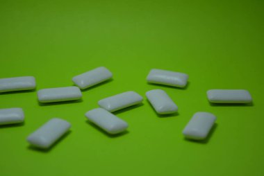 Yeşil kağıdın üzerinde beyaz sakız yastıkları var..